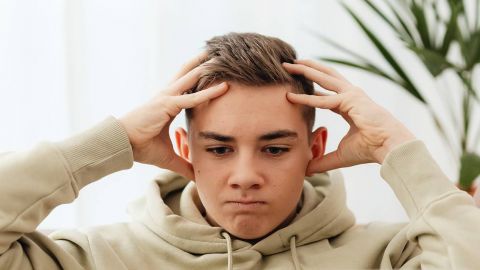 jeune homme déprimé, se prenant la tête