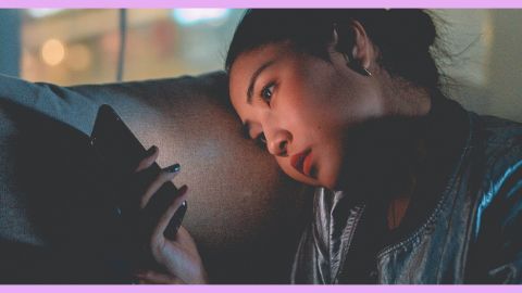 C'est quoi le fexting ? Une femme assise sur un canapé téléphone en main