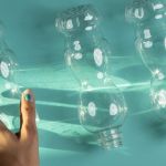 Une main qui s'approche de trois bouteilles en plastique