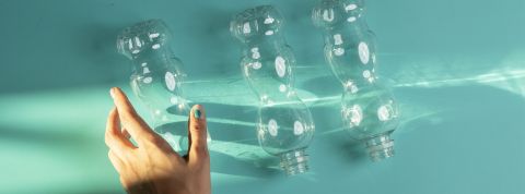 Les lobbies du plastique Une main qui s'approche de trois bouteilles en plastique