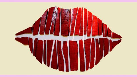 Une bouche rouge en papier découpé sur fond jaune