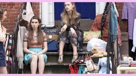 Quatre filles assises sur un escalier devant un immeuble de briques rouges