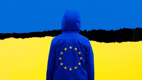 Une personne en veste bleue avec étoiles Europe et drapeau ukrainien en fond
