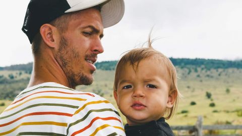 Un jeune père et son fils dans les bras