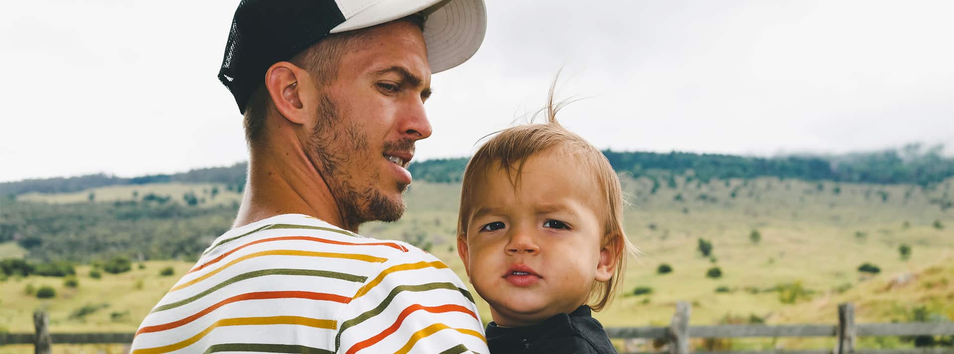 Un jeune père et son fils dans les bras