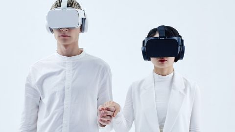 Un homme et une femme avec casques VR sur fond blanc
