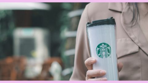 Une femme tient une boisson Starbucks