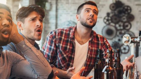 Amis de sexe masculin tristes, regarder le football à bar