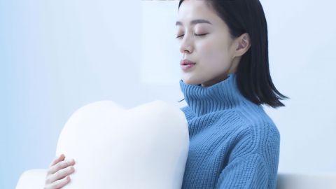 Une femme serrant un robot-coussin