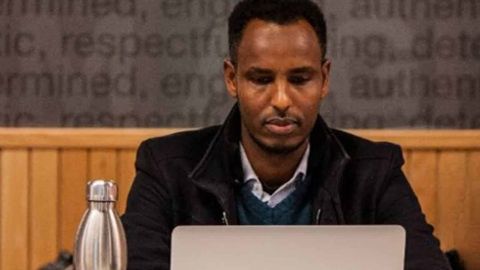 Un homme noir derrière un ordi