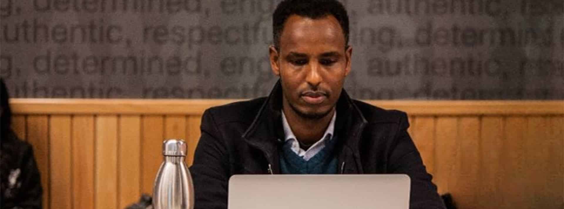 Les kényans exploités, horrifiés par ChatGPT Un homme noir derrière un ordi