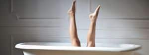 Des jambes de femme qui sortent d'une baignoire