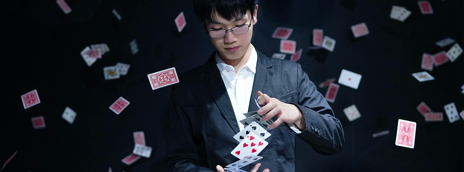 Illusioniste-cartes-volantes - L'ADN Un magicien fait un tour de cartes