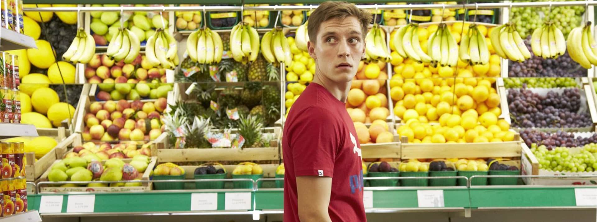 Jeune homme interloqué dans supermarché