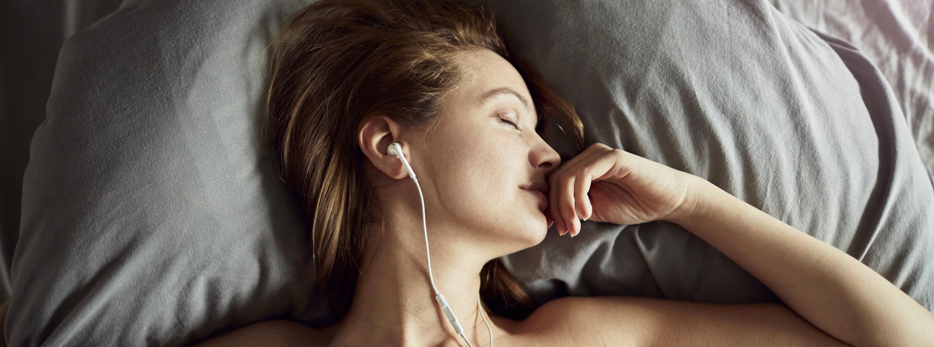 Une femme dort avec ses écouteurs