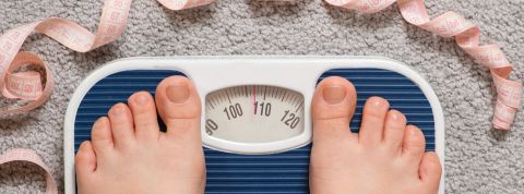 La France connaît une augmentation inquiètante de l'obésité 2 pieds sur une balance entourés par un mètre