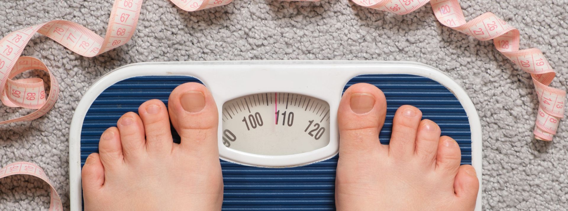 2 pieds sur une balance entourés par un mètre
