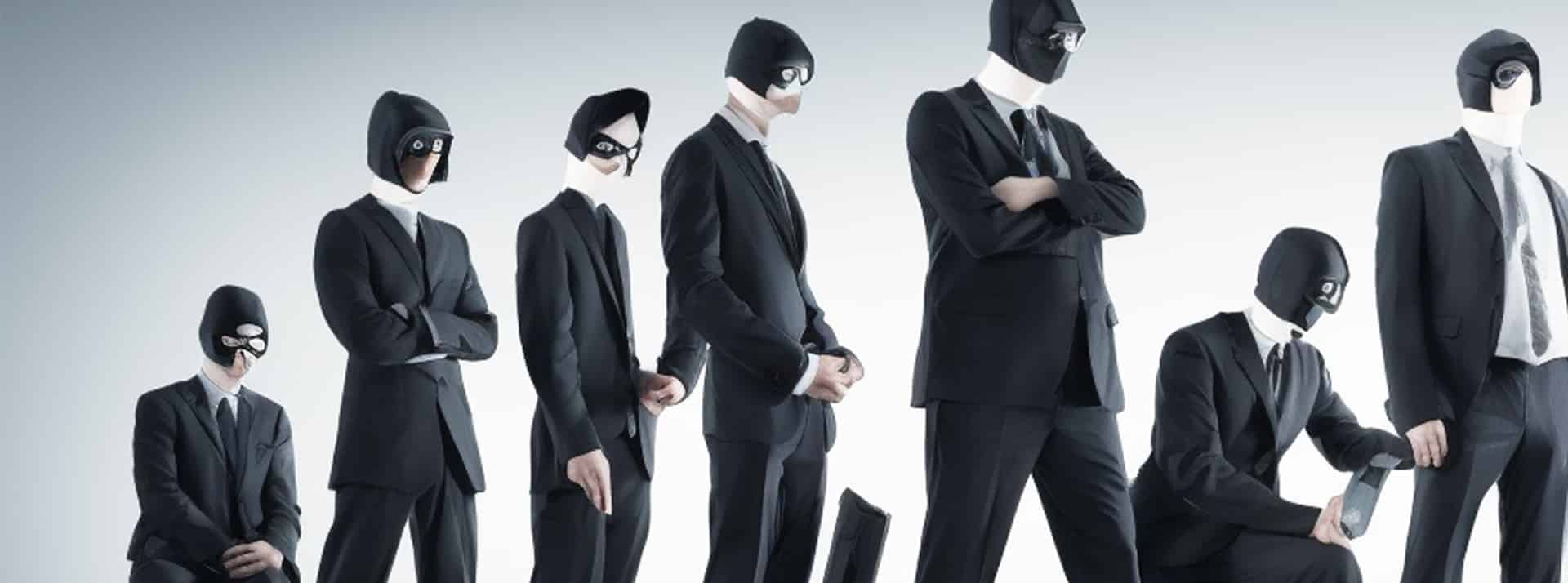 Les escrocs sur LinkedIn Une rangée de hackers en costumes vus de profil