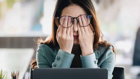 Femme epuisée avec les mains sur les yeux
