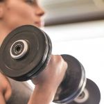 Jeune femme de profil avec poids dans les mains