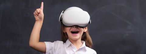 Intelligence artificielle, métavers : les élèves en France sont prêts à les adopter ! élève heureux et souriant utilisant un équipement de réalité virtuelle et suivant un enseignement à distance