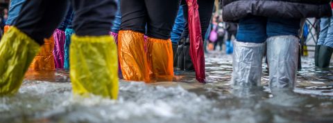 GIEC : Les actions peu chères et urgentes à mettre en place Des jambes de touristes à Venise pendant une inondation