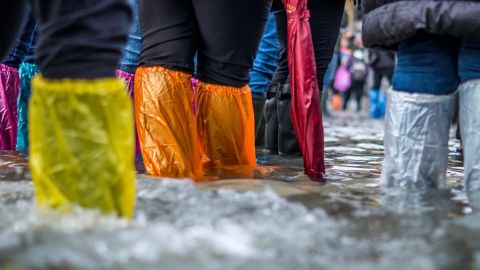 Des jambes de touristes à Venise pendant une inondation