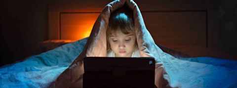 Phishing : Les enfants sont très vulnérables en ligne Jeune enfant sous sa couette avec un ordinateur