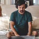 Un homme dans sa chambre travaille sur son ordi