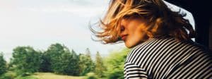 Femme cheveux au vent à la fenêtre d'un train