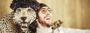 un homme hilare avec une panthère qui porte une perruque, photo style vintage