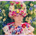 Une jeune fille avec une couronne de fleurs assise dans un champ