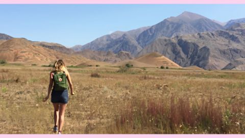 Une fille de dos devant les montagnes