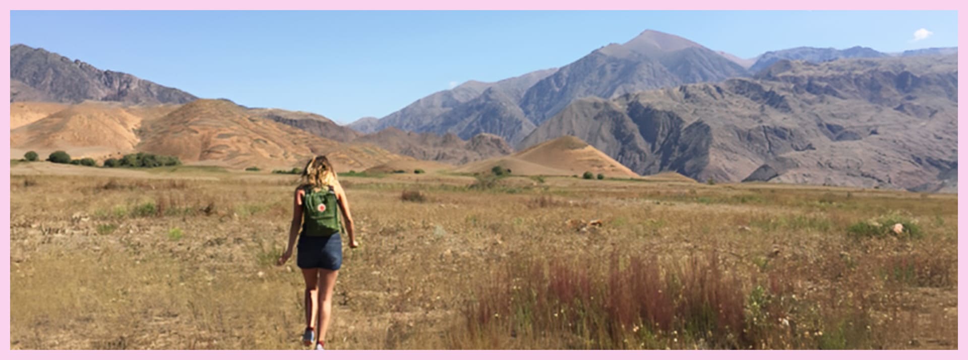 Une fille de dos devant les montagnes