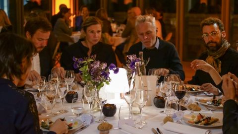 six personnes dînent autour d'une table ronde