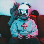 Un gamer portant un casque de moto miroir, assis dans son canapésans