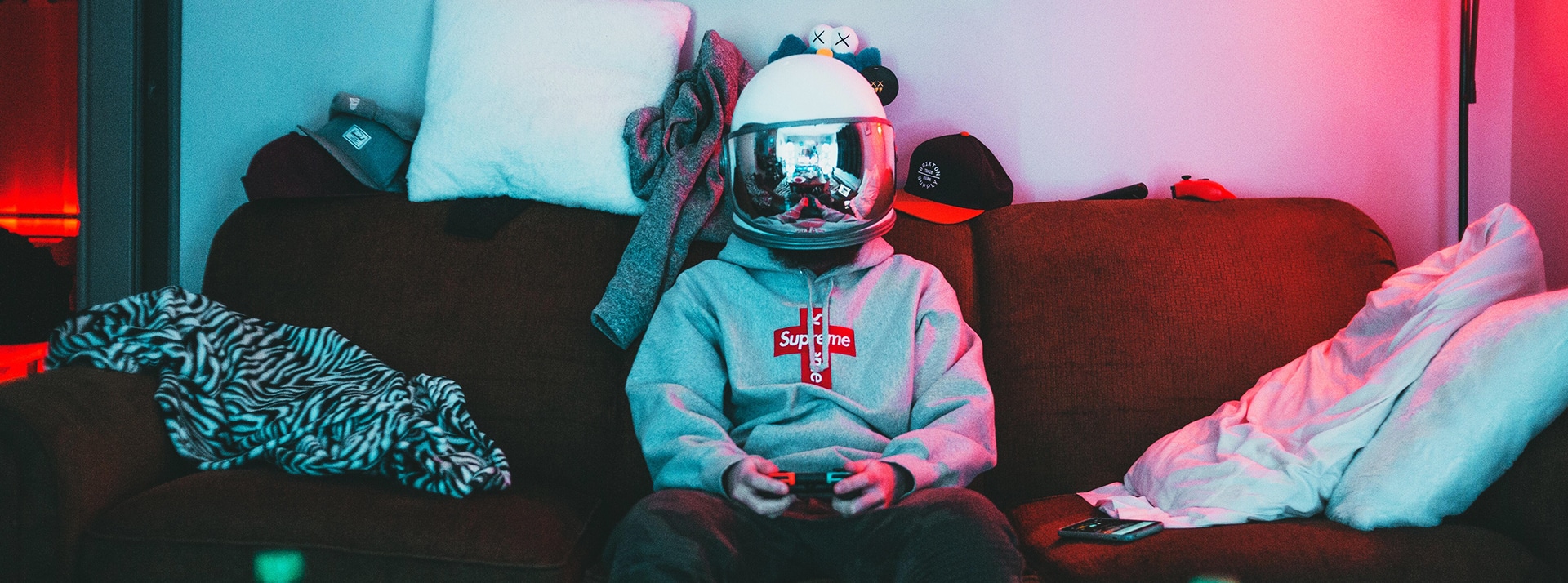 Un gamer portant un casque de moto miroir, assis dans son canapésans