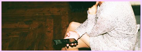 C'est quoi les date-me docs ? Une fille assisse en robe avec un téléphone en main