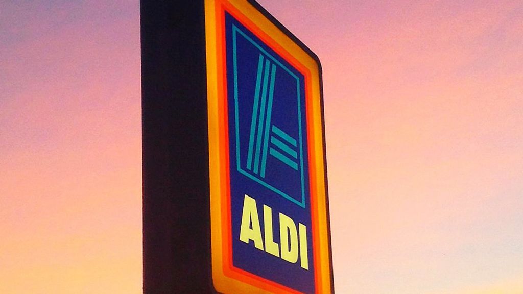 Une enseigne Aldi sur un ciel rose de fin de journée