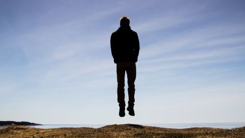 un homme lévite sur une plage