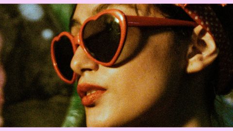 Une femme qui porte des lunettes rouge en forme de cœur