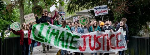 Premier grand procès climatique aux Etats-Unis Jeunes manifestants tenant une banderole : climate justice