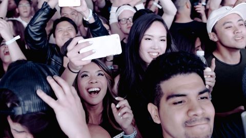 Une foule heureuse tenant en l'ai leurs smartphones