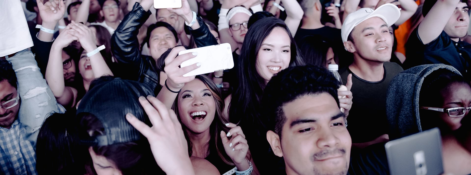 Le 21ème siècle sera low tech - L'ADN Une foule heureuse tenant en l'ai leurs smartphones