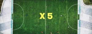 Un terrain de foot vu du ciel avce le symbole multiplier x 5