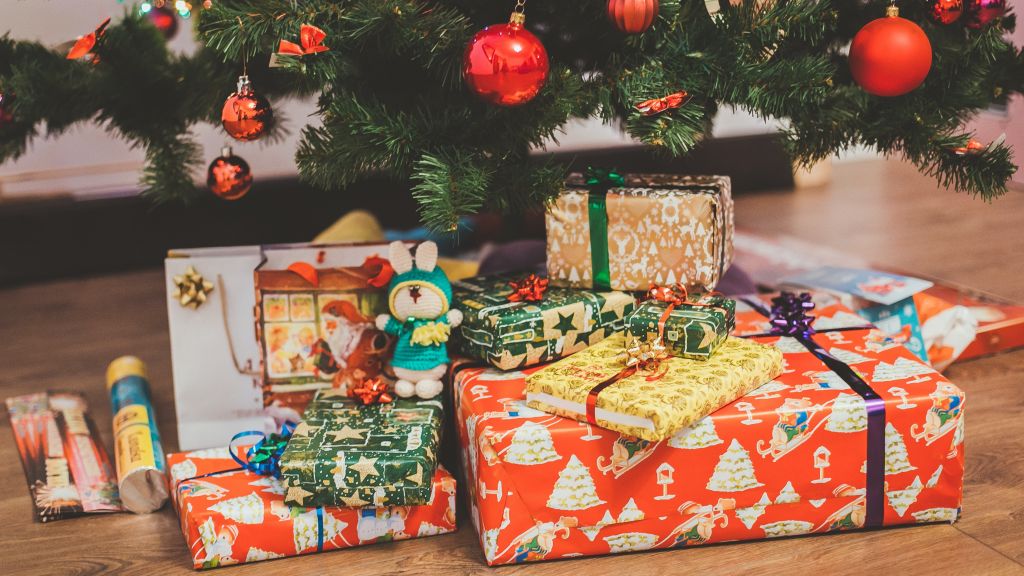 Photo de Eugene Zhyvchik -Unsplash plusieurs cadeaux de noël sous un sapin décoré