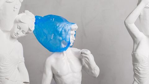 Des statues dont l'une avec un sac plastique bleu sur la tête