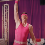 une homme en maillot rose soulève une althère