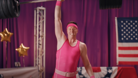 une homme en maillot rose soulève une althère