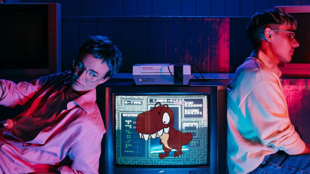 deux teenagers à côté d'une télé avec le Raptor